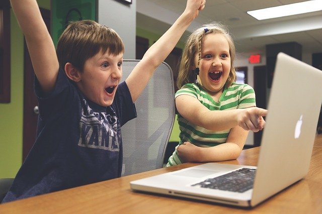 パソコンの前で喜ぶ子供たち