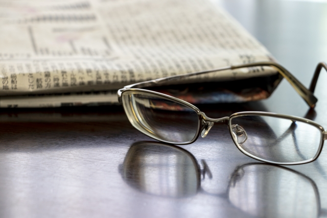 机の上の新聞紙と眼鏡